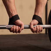 Athlete gripping a barbell with black weight lifting straps